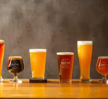 three clear drinking glasses on brown wooden table