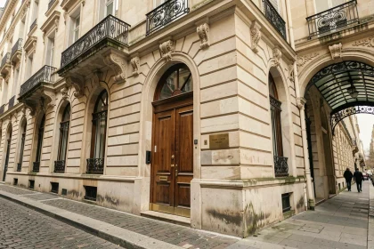 Façade haussmannienne du 2 Rue Vivienne à Paris avec l'entrée de la galerie Colbert visible sous un arc en pierre