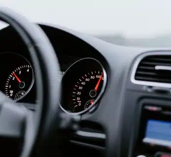 black vehicle dashboard with speedometer on 100