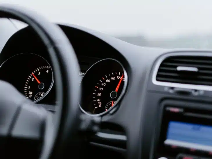 black vehicle dashboard with speedometer on 100